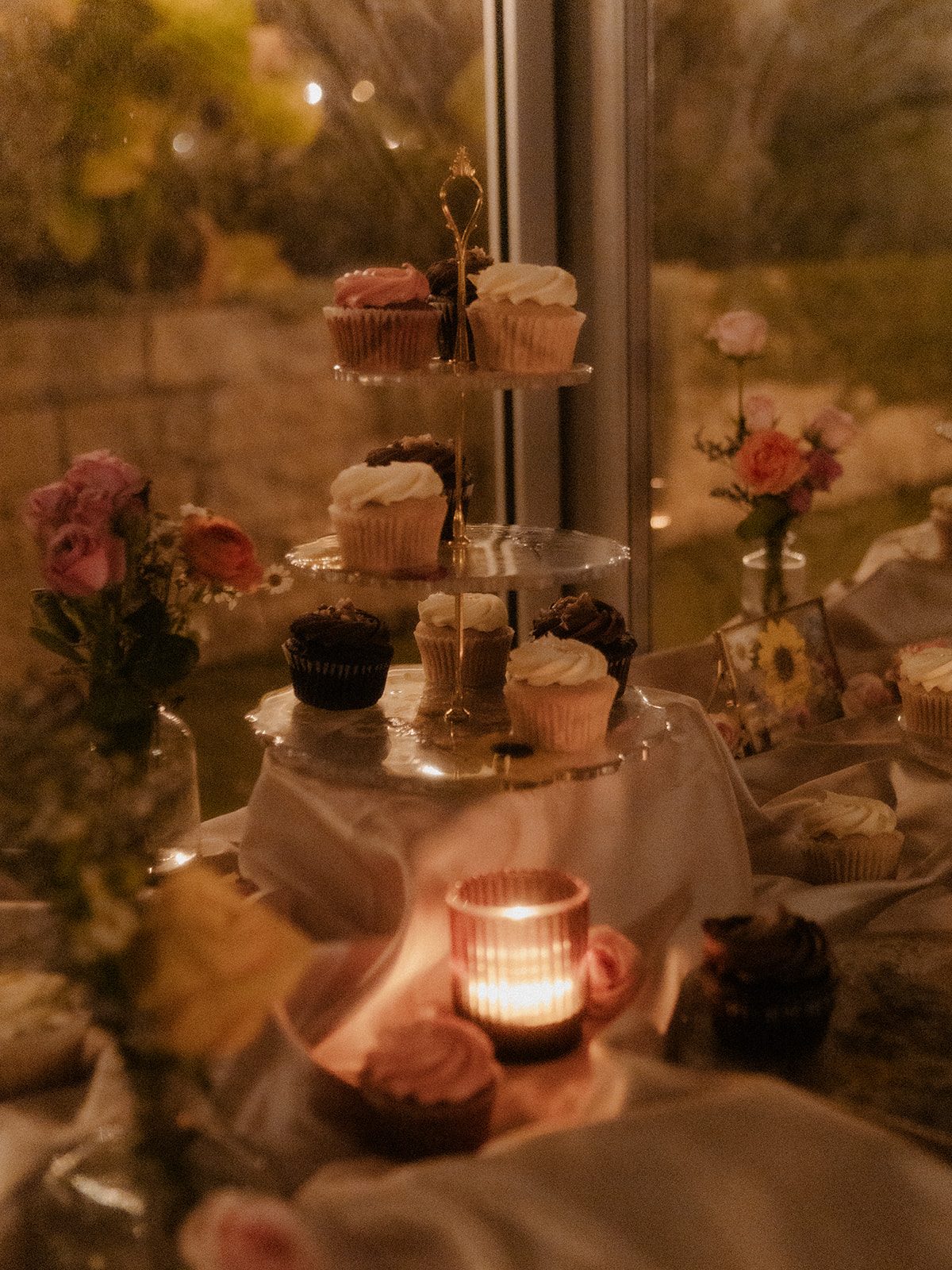Tiered cupcake and candy display with candlelight